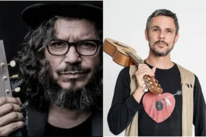 Dos hombres aparecen uno al lado del otro. El hombre de la izquierda tiene el pelo rizado, lleva gafas y sombrero, y sostiene una guitarra. El hombre de la derecha, con pelo corto y barba incipiente, sostiene un pequeño instrumento de cuerda, listo para tocar flamenco en la Fiesta del PCE 2025.