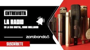 Varios micrófonos profesionales se agrupan sobre un fondo rojo. A la izquierda, el texto reza: Entrevista: La radio digital en la era digital sigue brillando, con un icono de campana, zarabandas y un botón rojo Suscríbete debajo.