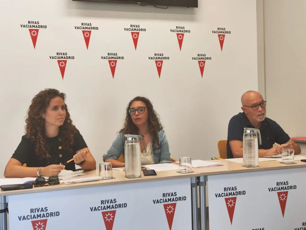 Rueda de prensa posterior a la Junta de Gobierno Local de Rivas-Vaciamadrid. Comparecen Mónica Carazo (izquierda), vicealcaldesa; Aída Castillejo (centro), alcaldesa; José Alfaro (derecha), portavoz del Gobierno. En la pared detrás de ellos se repiten los logotipos de Rivas Vaciamadrid.