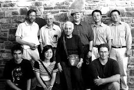 Un grupo de nueve adultos, entre ellos la célebre matemática española María Wonenburger, posan en dos filas frente a un muro de piedra. Cuatro están sentados o arrodillados delante, y cinco de pie detrás de ellos. La foto es en blanco y negro.