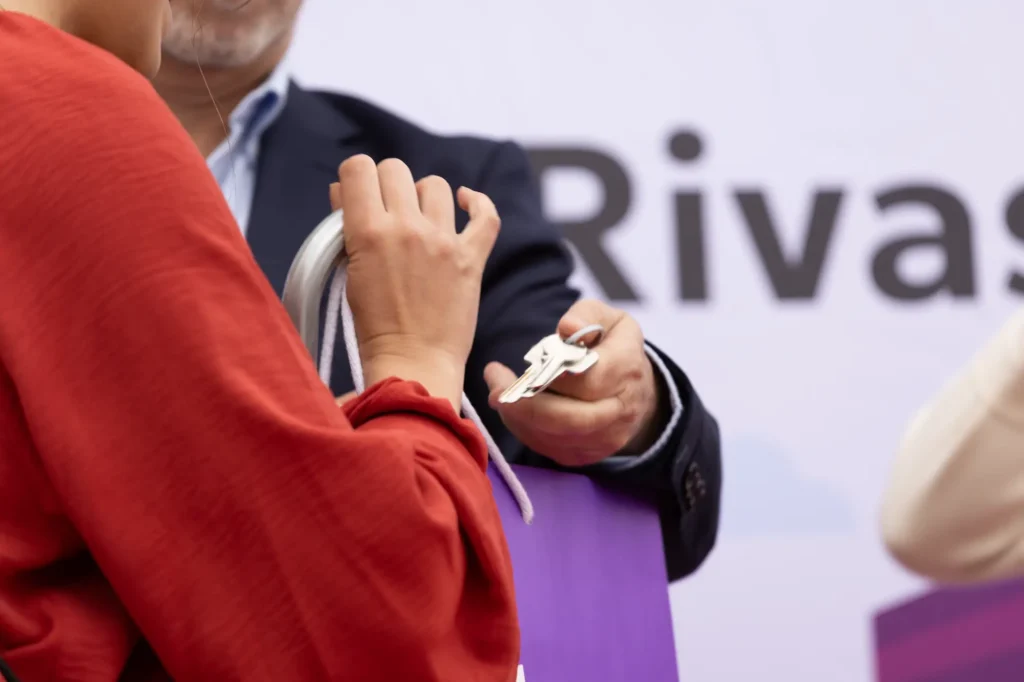 Una persona con camisa roja recibe un juego de llaves. Imagen reprsentativa de lo que fue la ceremonia de entrega de las 83 viviendas en Rivas.