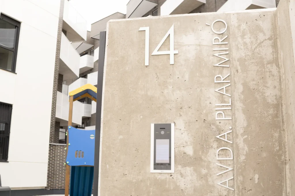 Un muro de hormigón muestra el número 14 y el texto AVDA. PILAR MIRO en letras blancas, que es donde están ubicadas las 83 viviendas que entrega el Ayuntamiento a jóvenes ripenses.