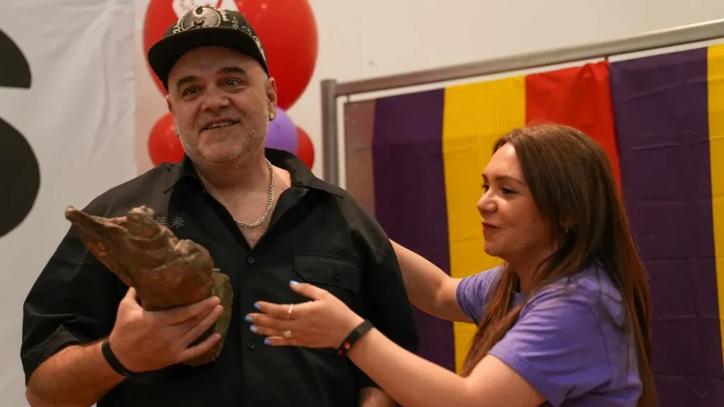 El premiado de Grimey recibe su galardón de manos de la alcaldesa Aída Castillejo. Globos de colores y una bandera a rayas alegran el acto al que asisten 500 personas.