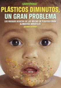 Un bebé con comida en la cara mira a la cámara. La imagen lleva un titular de Greenpeace en español, creado con borrador automático, que advierte de los riesgos de los plásticos pequeños en los envases de alimentos infantiles.