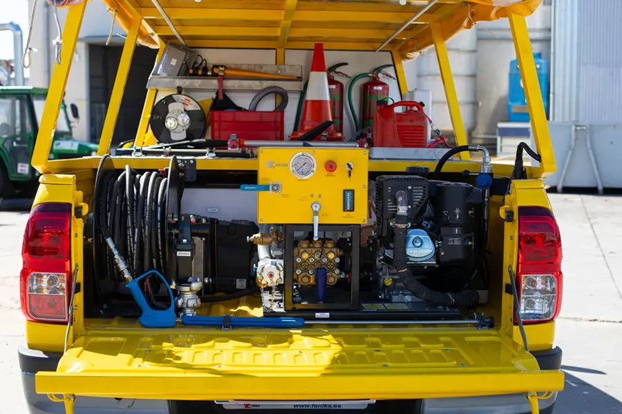 Una camioneta pick-up amarilla, con el portón trasero y la capota abiertos, muestra un sistema de hidrolavado, mangueras, un panel de control y el equipo ordenado en la caja, ideal para las operaciones de la campaña contra incendios de Rivamadrid.
