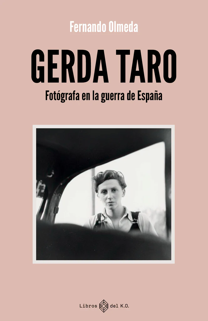 Portada del libro con fondo rosa en la que aparece el título «Gerda Taro: Fotógrafa en la guerra de España», el libro de Fernando Olmeda. Debajo del título hay una fotografía en blanco y negro de Gerda Taro mirando a la cámara.
