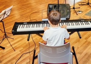 Niño tocando el piano en un taller cultural de la EMAR de Rivas