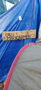 Cartón que nombra «calle Maricarmen» el campamento de la Puerta del Sol
