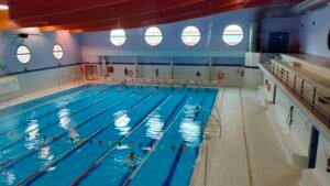 Piscina cubierta del polideportivo Parque del Sureste de Rivas, con varios nadadores en las calles