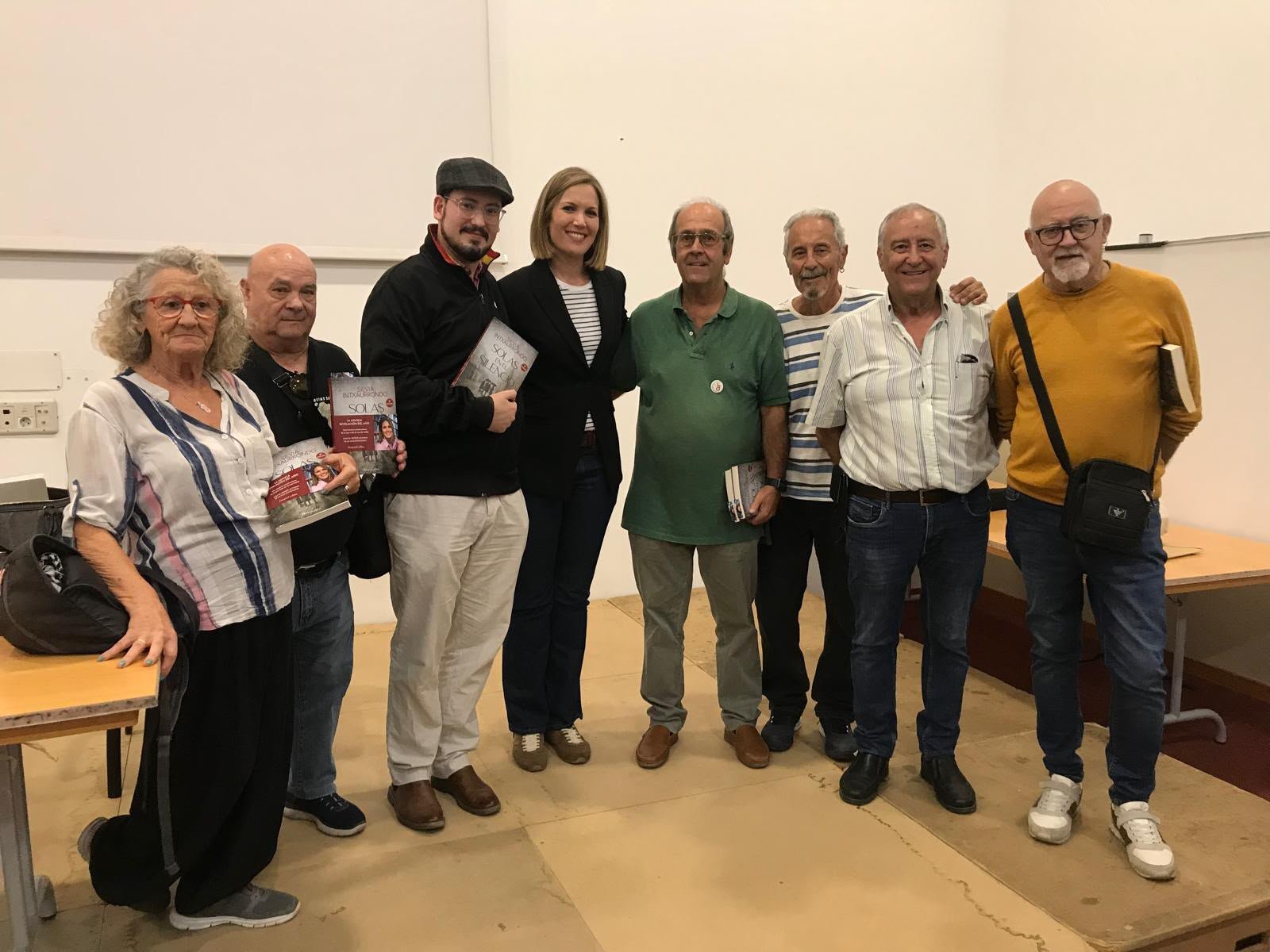 Un grupo de personas posa con ejemplares del libro Solas