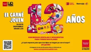 Cartel promocional del Carné Joven de Madrid en el que aparecen el número 12 a gran tamaño, un código QR y un texto que invita a los jóvenes a solicitar su Carné Joven gratuito para disfrutar de descuentos y ventajas.