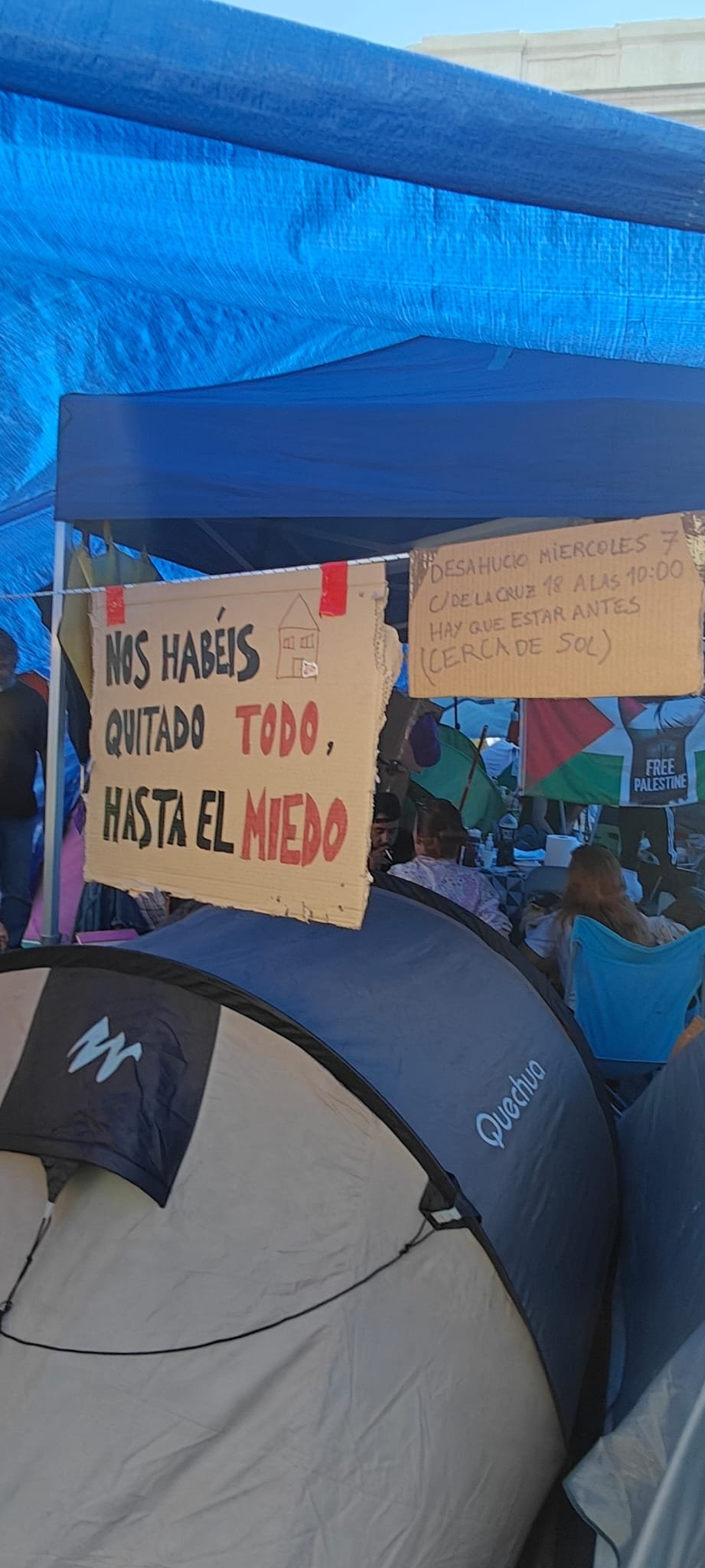 Cartones de la acampada con el lema «Nos habéis quitado todo, hasta el miedo» y el aviso de un desahucio