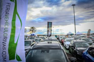 Filas de coches nuevos y de ocasión en el recinto ferial de Rivas, con banderas de la Feria del Vehículo Sostenible y el cartel de Ocasión