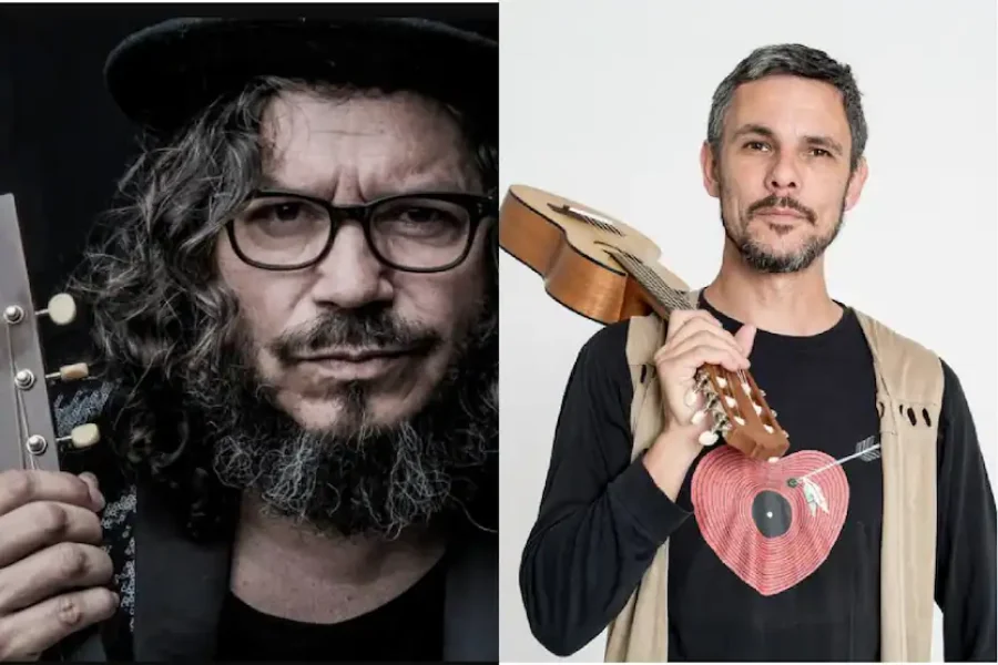 Dos hombres aparecen uno al lado del otro. El hombre de la izquierda tiene el pelo rizado, lleva gafas y sombrero, y sostiene una guitarra. El hombre de la derecha, con pelo corto y barba incipiente, sostiene un pequeño instrumento de cuerda, listo para tocar flamenco en la Fiesta del PCE 2025.