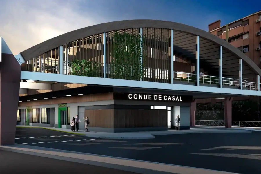 Este intercambiador de Conde de Casal, un edificio moderno con tejado curvo etiquetado Conde de Casal, presenta elementos de cristal y metal, grandes ventanales, vegetación en lo alto y peatones cerca. Al fondo, altos edificios de apartamentos.