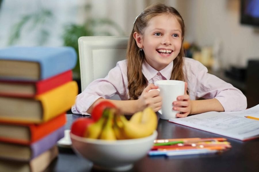 Una niña desayuna leche y fruta en su casa | Foto de Servimedia