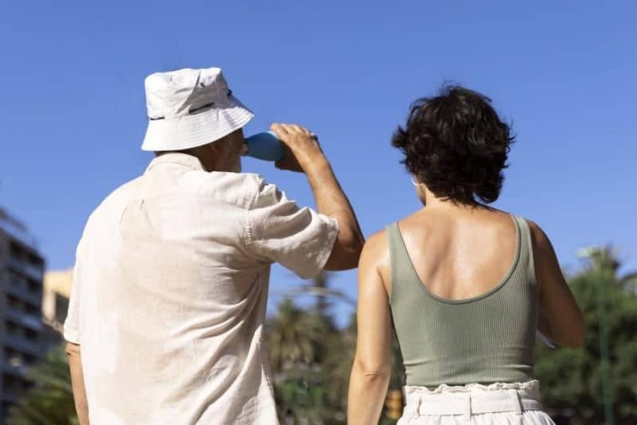 Un hombre, acompañado de una mujer, combate las altas temperaturas bebiendo agua | Foto: Servimedia