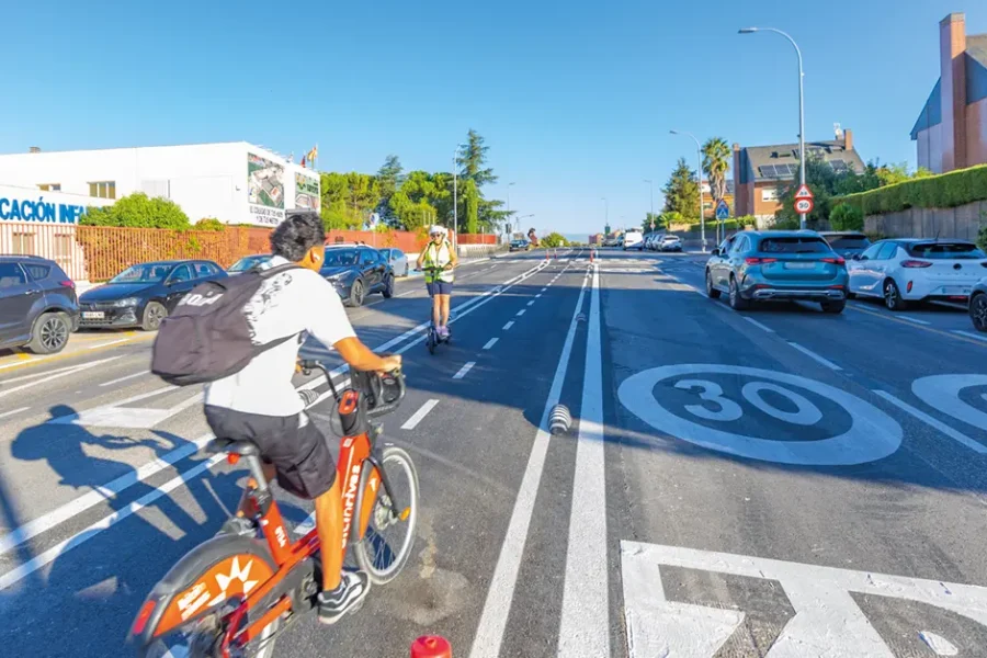 Un ciclista y una persona en patinete circulan por el carril bici de Rivas en la calle Junkal. (Fotografía de Paco Mariscal).