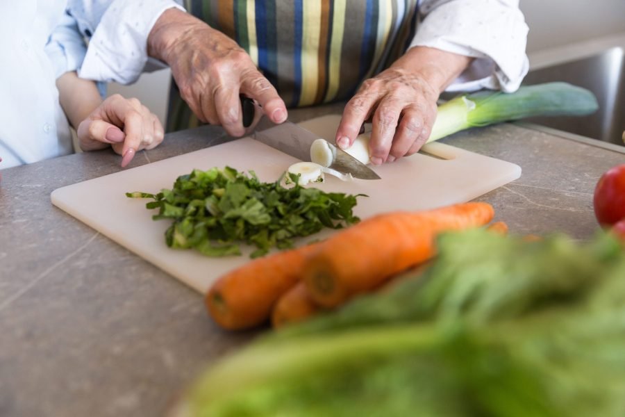 Una persona mayor cocina en su domicilio