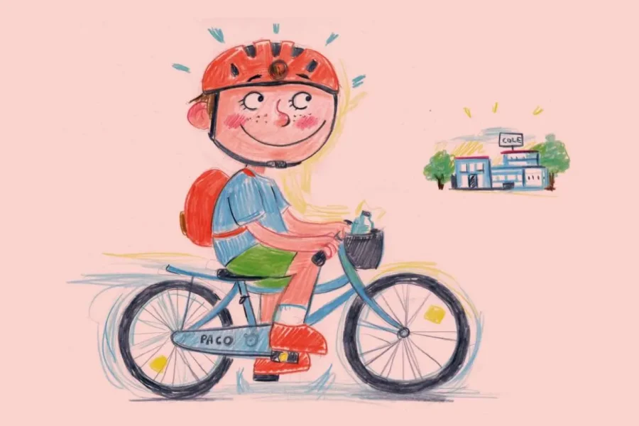 Un niño con casco rojo y mochila va en una bicicleta con el nombre «Paco» escrito en ella, en dirección a un edificio con un cartel que dice «Casa», lo que plasma a la perfección la alegría de ir al cole en bici con los peques. El niño sonríe y hay un vaso en el portavasos de la bicicleta. El fondo es de color rosa claro, con un estilo de dibujo esbozado.