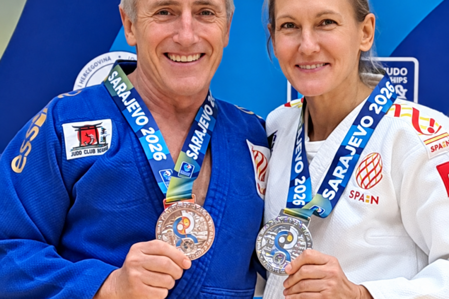 Ana Roldán y Paco Lorenzo, con los quimonos y las medallas de plata del Mundial máster de judo de Sarajevo, posan ante un panel del campeonato