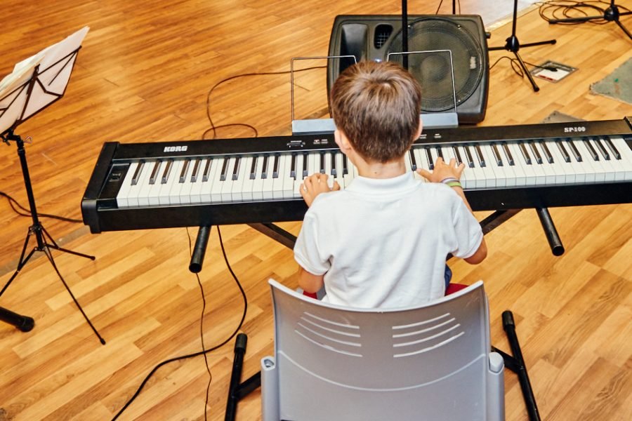 Niño tocando el piano en un taller cultural de la EMAR de Rivas
