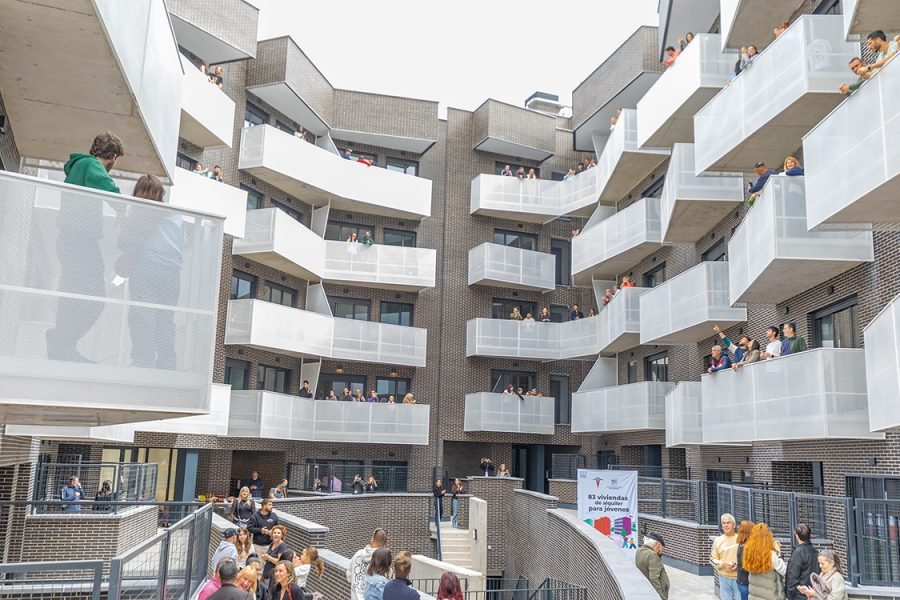 Vecinos asomados a los balcones durante la entrega de una promoción de vivienda protegida de alquiler de la EMV en Rivas