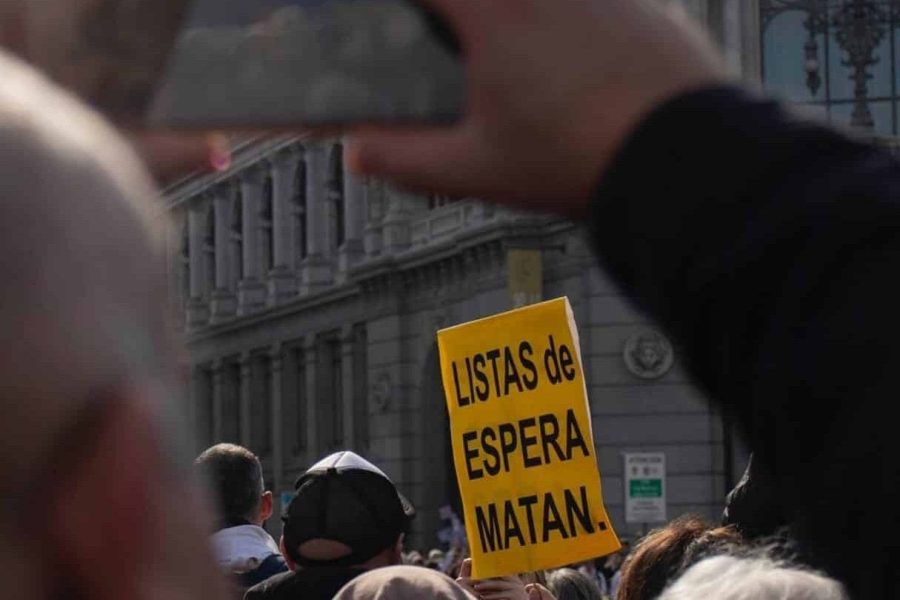 Cartel "Listas de espera matan" sostenido por un manifestante. El equipo de gobierno del Ayuntamiento de Rivas reivindica la sanidad y la educación públicas frente a Ayuso.