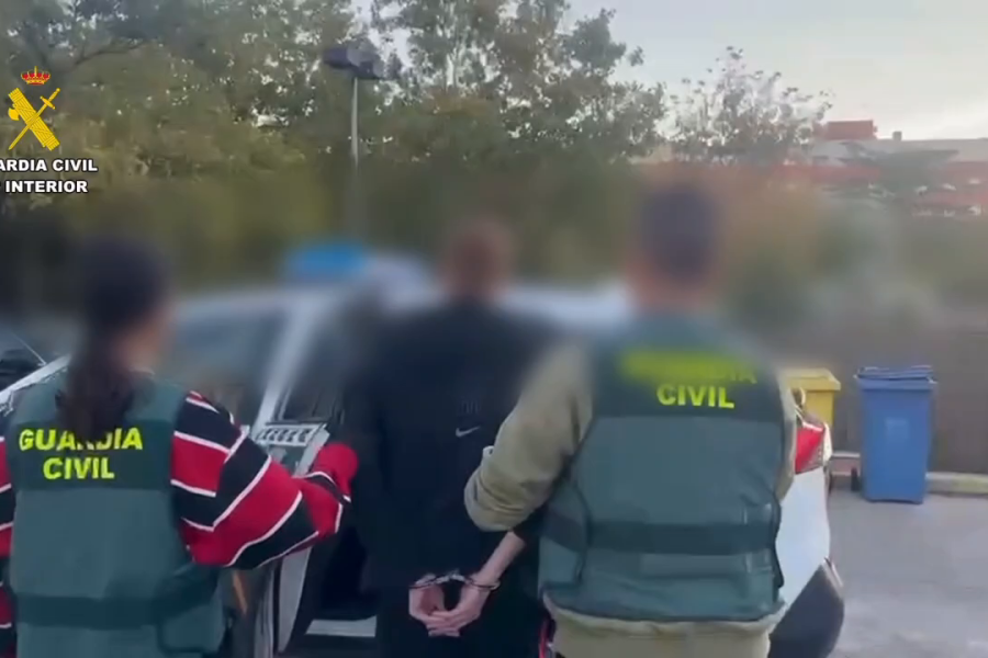 Dos agentes de la Guardia Civil conducen al detenido esposado hacia el coche patrulla en Rivas Vaciamadrid