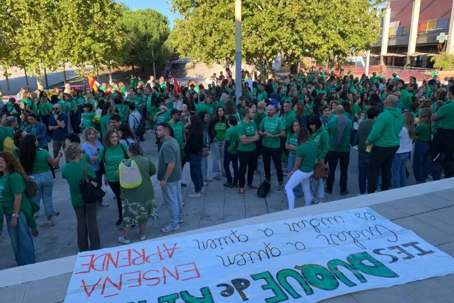 Un numeroso grupo de personas con camisetas verdes, que forman parte de la marea verde, se encuentra en una plaza detrás de una pancarta en la que se lee: IES DUQUE DE RIVAS ENSEÑA A QUIEN CUIDAR A QUIEN APRENDE.
