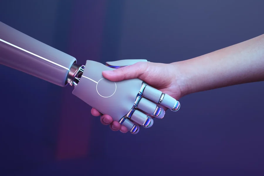 Una mano humana se da la mano con una mano robótica plateada sobre un fondo morado con degradado, lo que simboliza la interacción o colaboración entre los seres humanos y la tecnología y pone de relieve el impacto de la IA en el empleo, tal y como ha analizado BBVA Research.