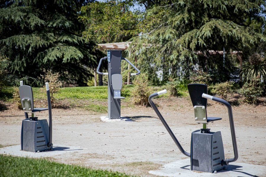 Área biosaludable con aparatos de ejercicio entre arbolado en el entorno del CEIPSO La Luna, una de las intervenciones del proyecto Renatura Rivas en el barrio Oeste